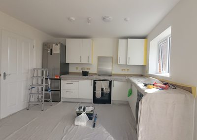 Kitchen before decorating, worktops sheeted and edges masked